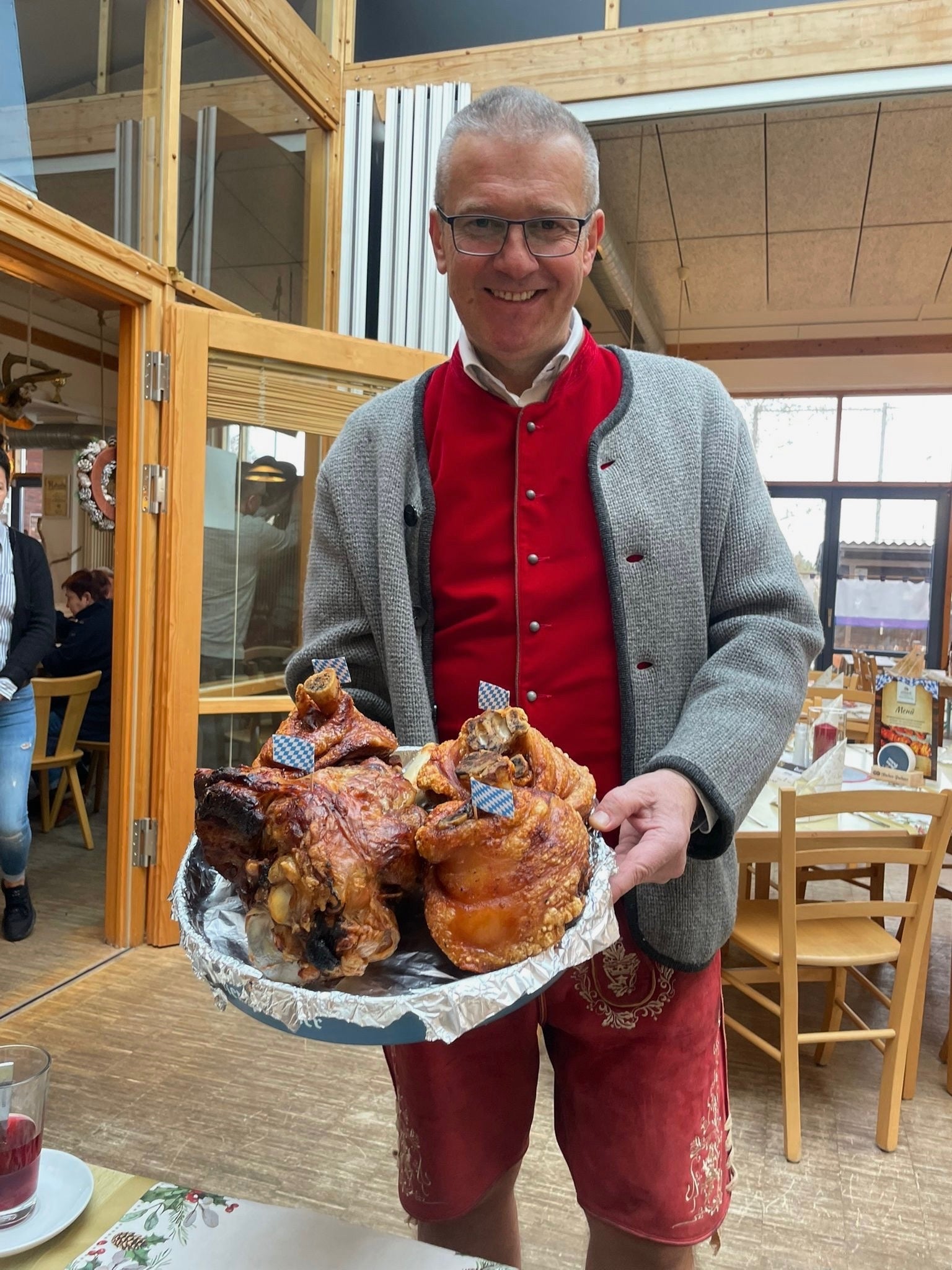 Dusan Musulin in Tracht mit frisch gegrillten Haxn